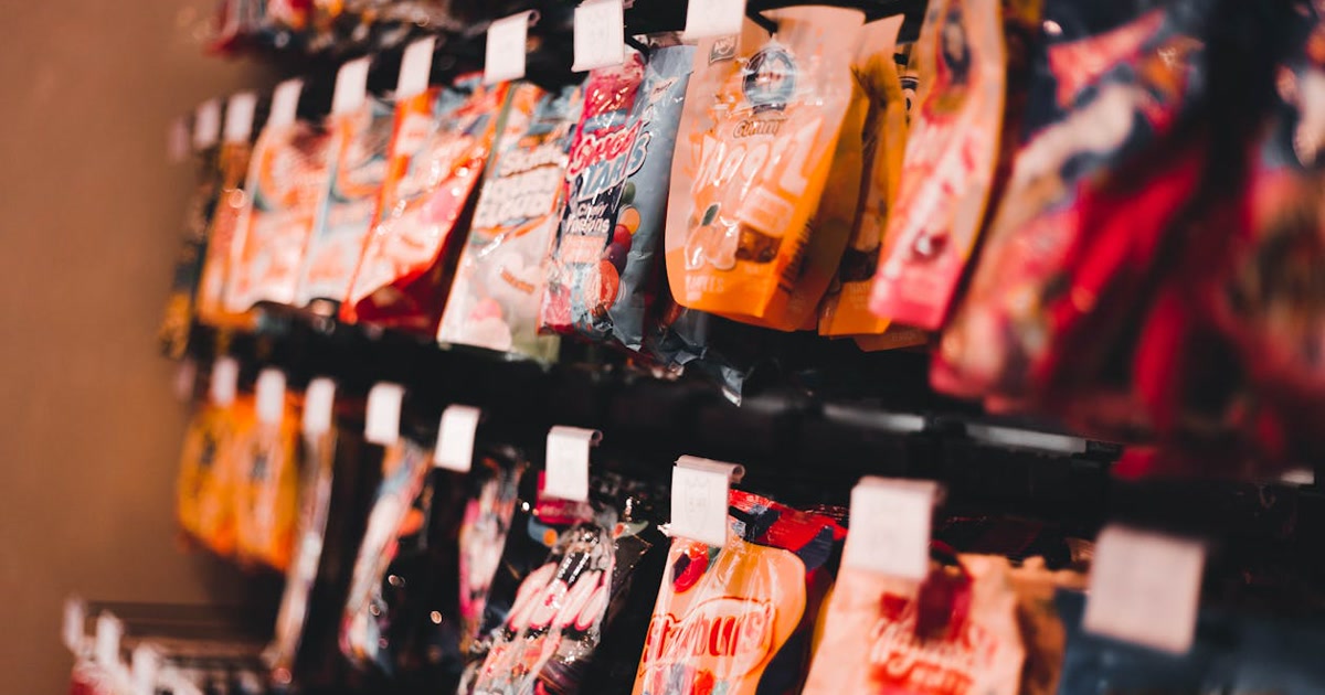 Variety of ultra-processed foods including chips, soda, and packaged snacks